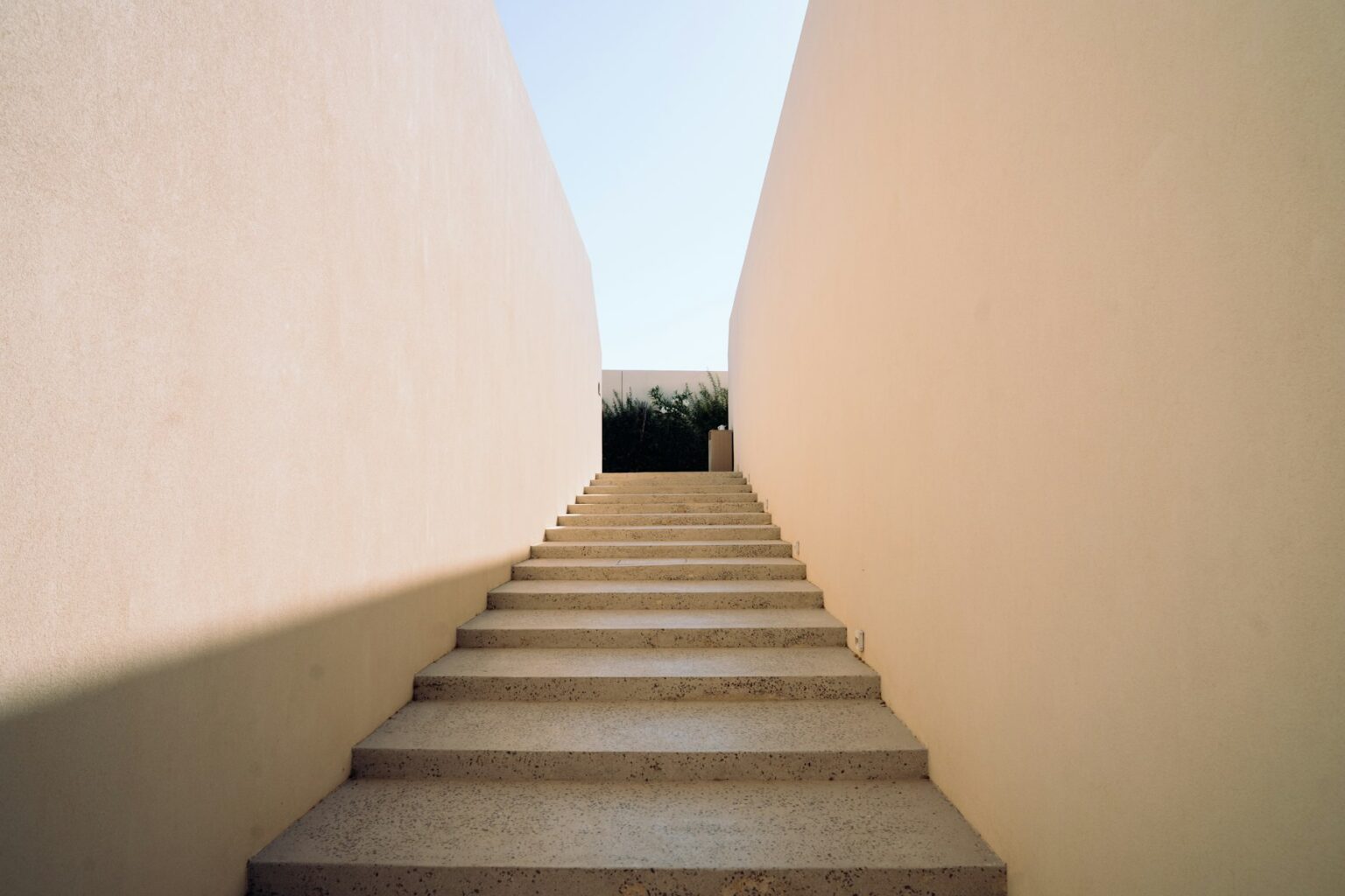 Escalera de piedra entre dos muros altos de mortero de cal, abierta al cielo
