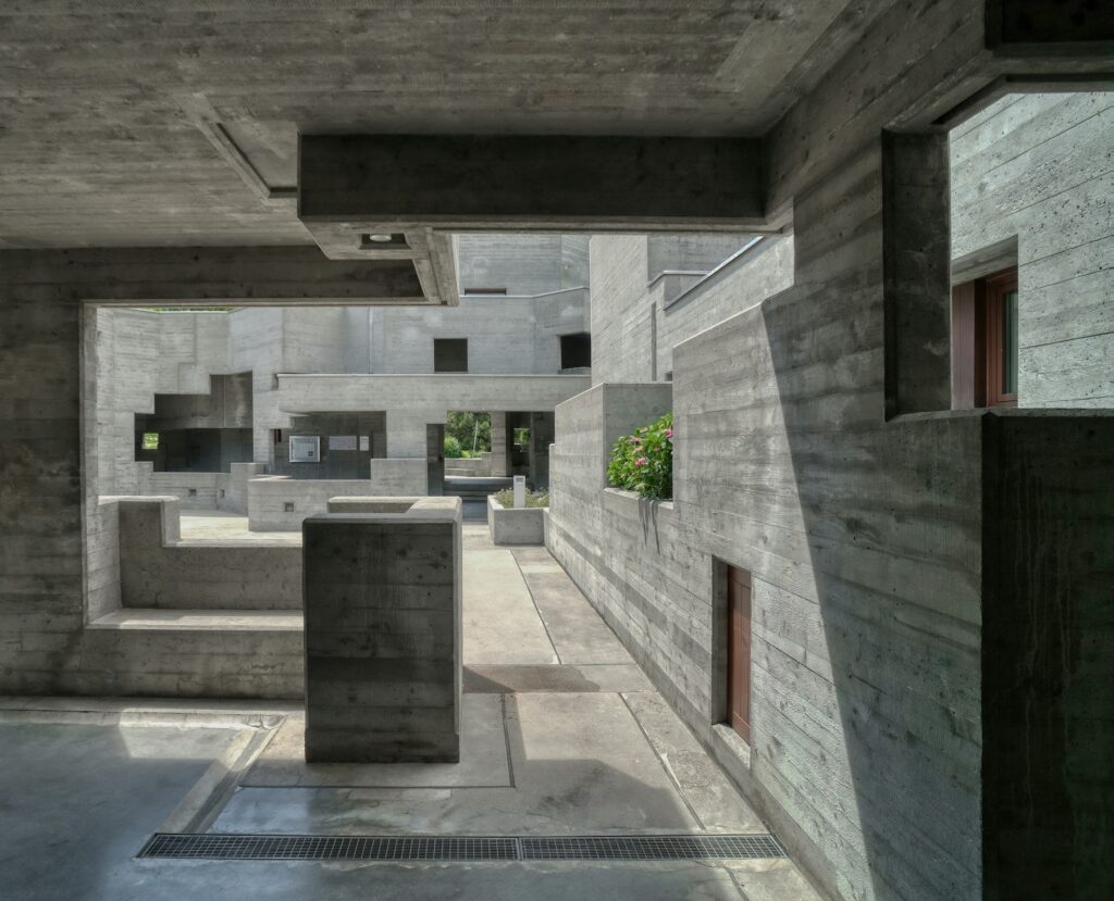 Patio interior entre volúmenes de hormigón encofrado con tablas